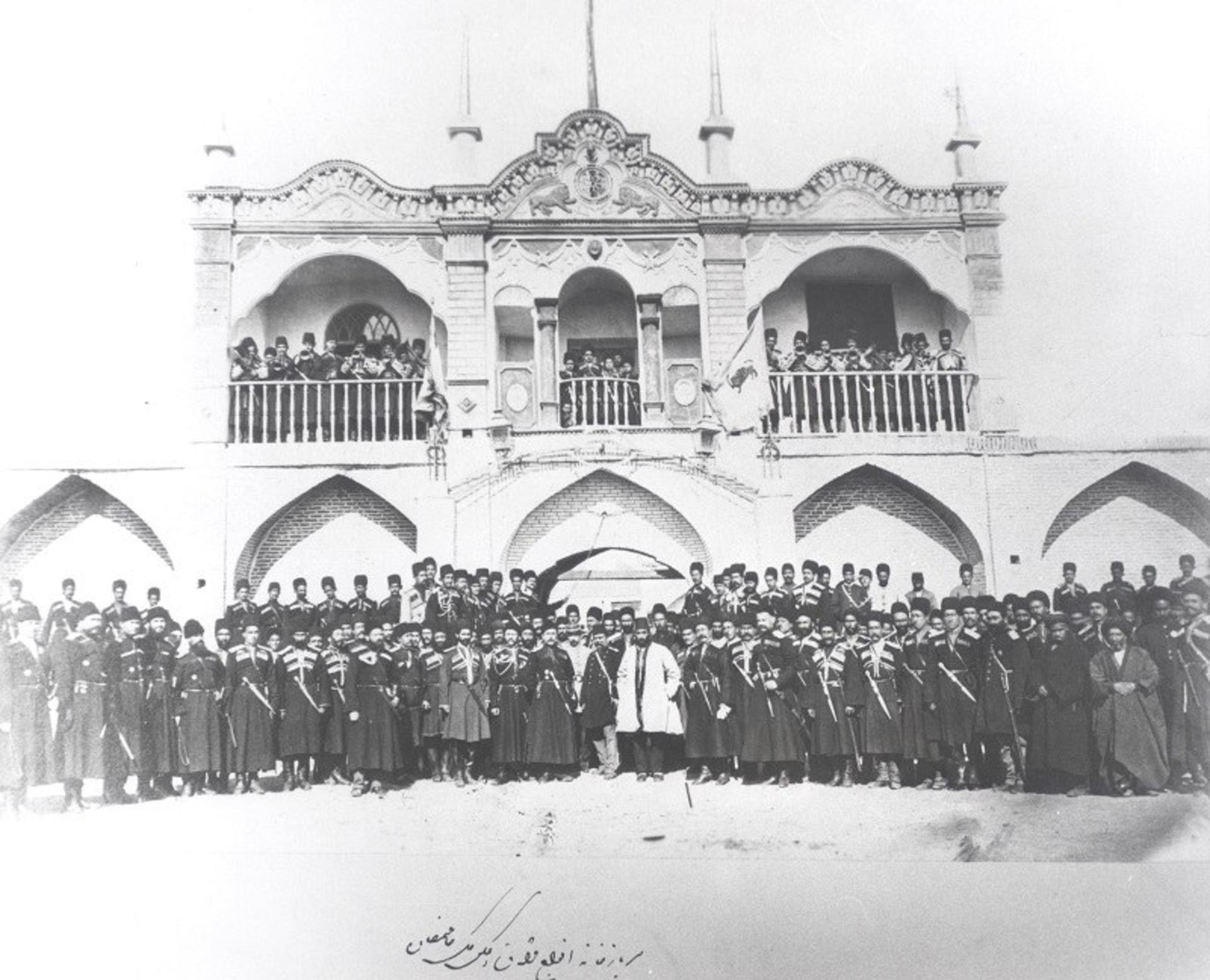 عکس دسته جمعی با عمارت در عکس آلبوم خانه کاخ گلستان؛ منبع عکس: آلبوم خانه کاخ گلستان. عکاس: نامشخص