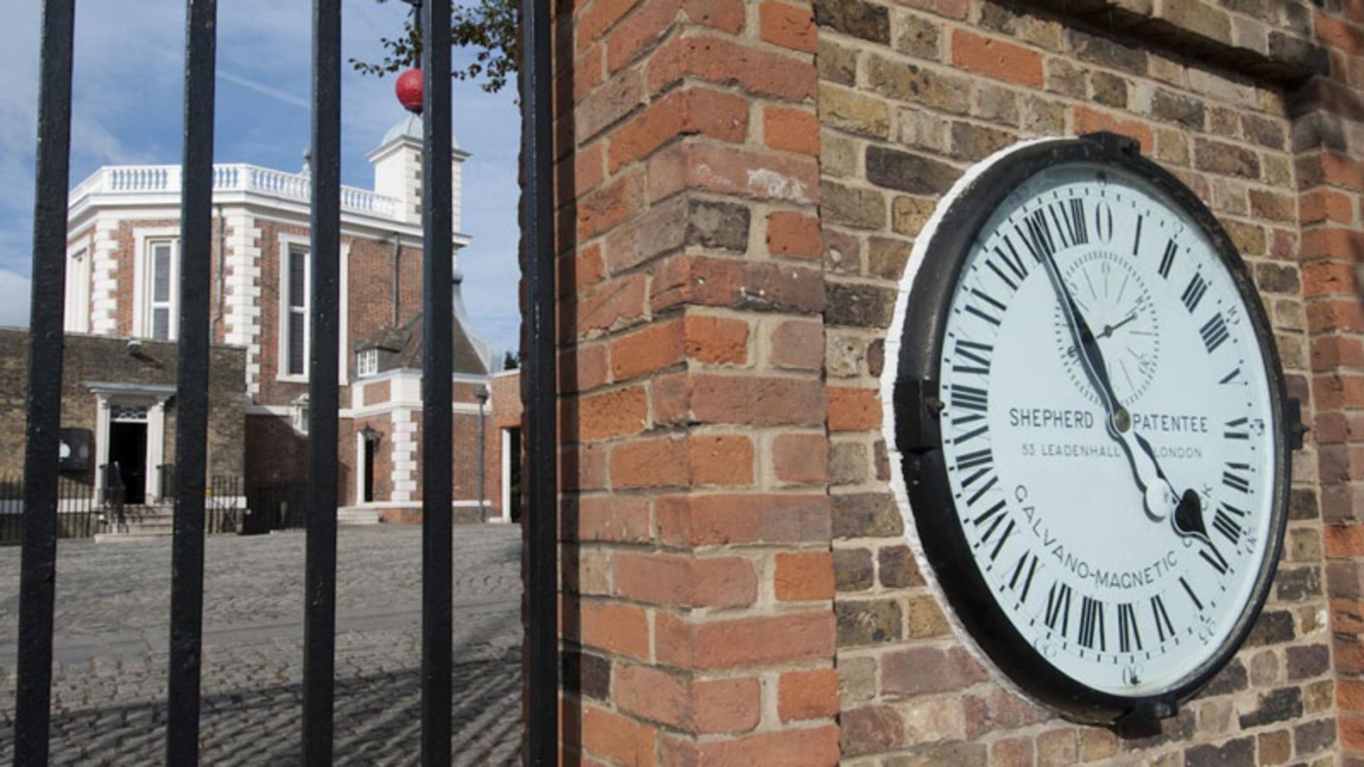 ساعت گرینویچ بر دیوار آجری حصار ساختمان؛ منبع عکس: Royal Museums Greenwich