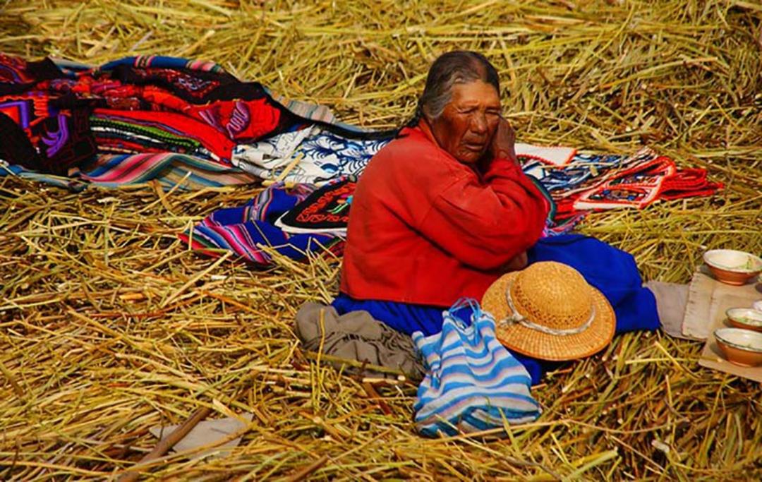 پیرزن آمریکای لاتین کنار لباس های رنگی