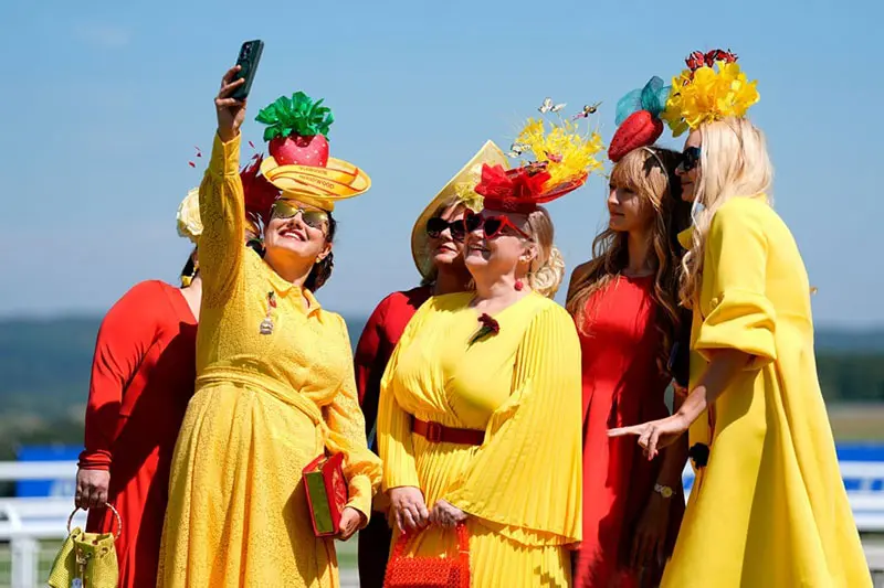 سلفی زنان با لباس‌های زرد و قرمز در روز اول جشنواره گودوود قطر (Qatar Goodwood festival) در انگلستان