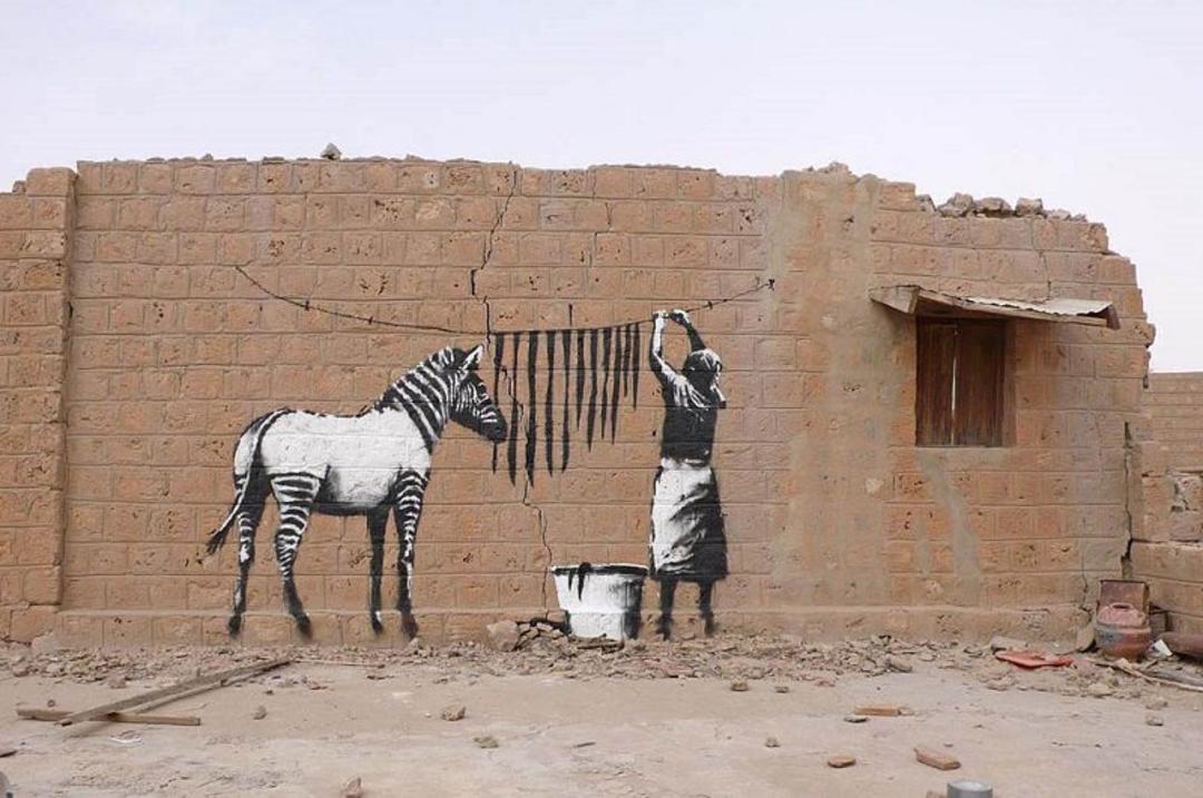 نقاشی دیواری شستن خط های گوره خر اثر بنکسی؛ منبع عکس وب سایت Banksy.co.uk