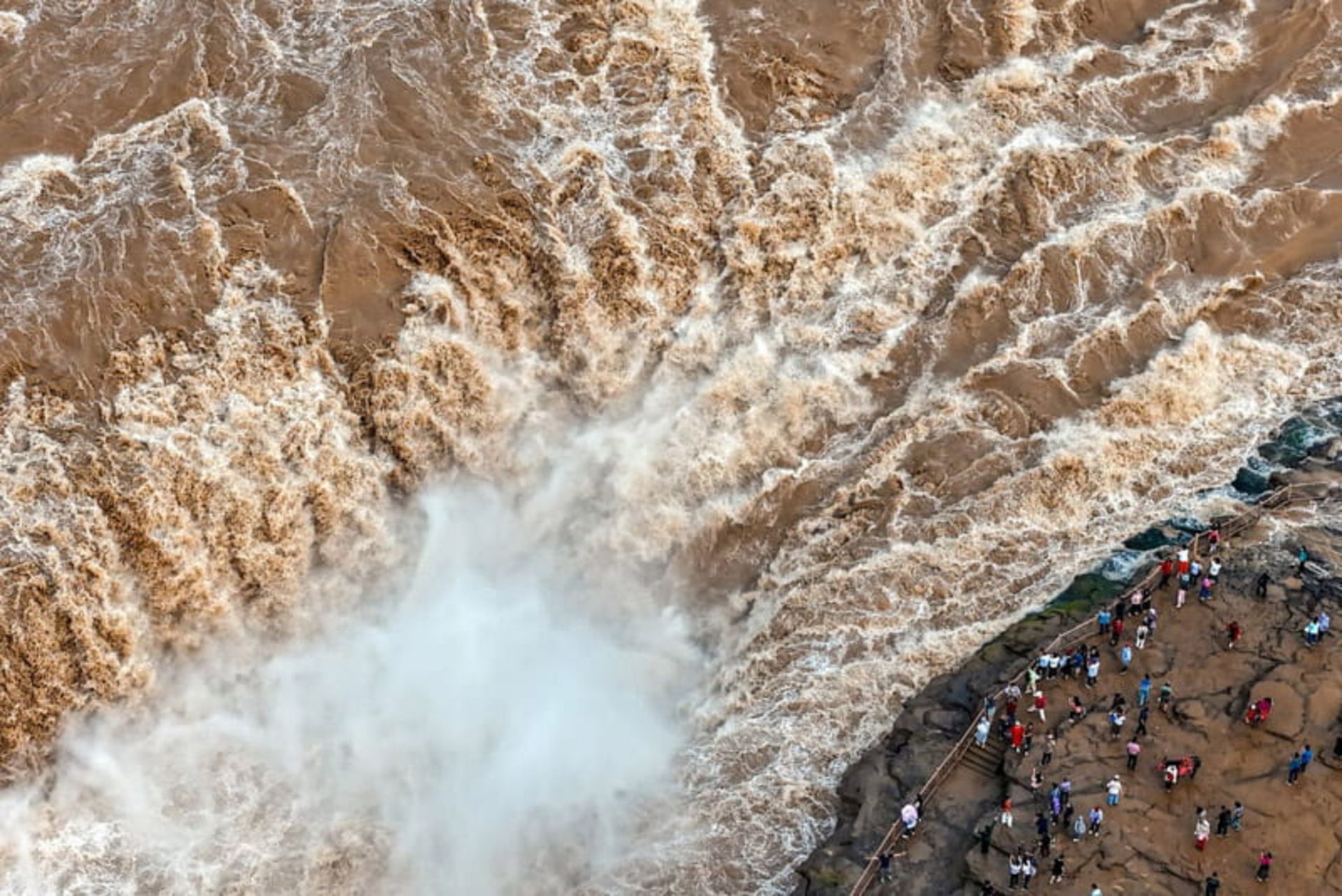 بازدیدکنندگان در حال تماشای آبشار هوکو (Hukou waterfall) بر روی رودخانه زرد در شمال استان شانشی (Shanxi) چین 
