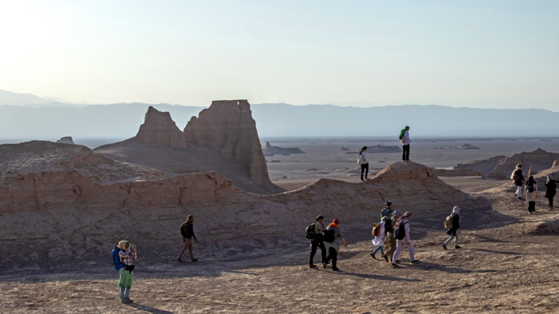 عبور گردشگران از کنار صخره های کویر شهداد کرمان
