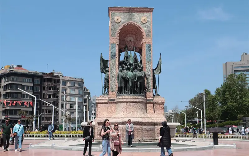 گردشگران در اطراف یادبود میدان تکسیم