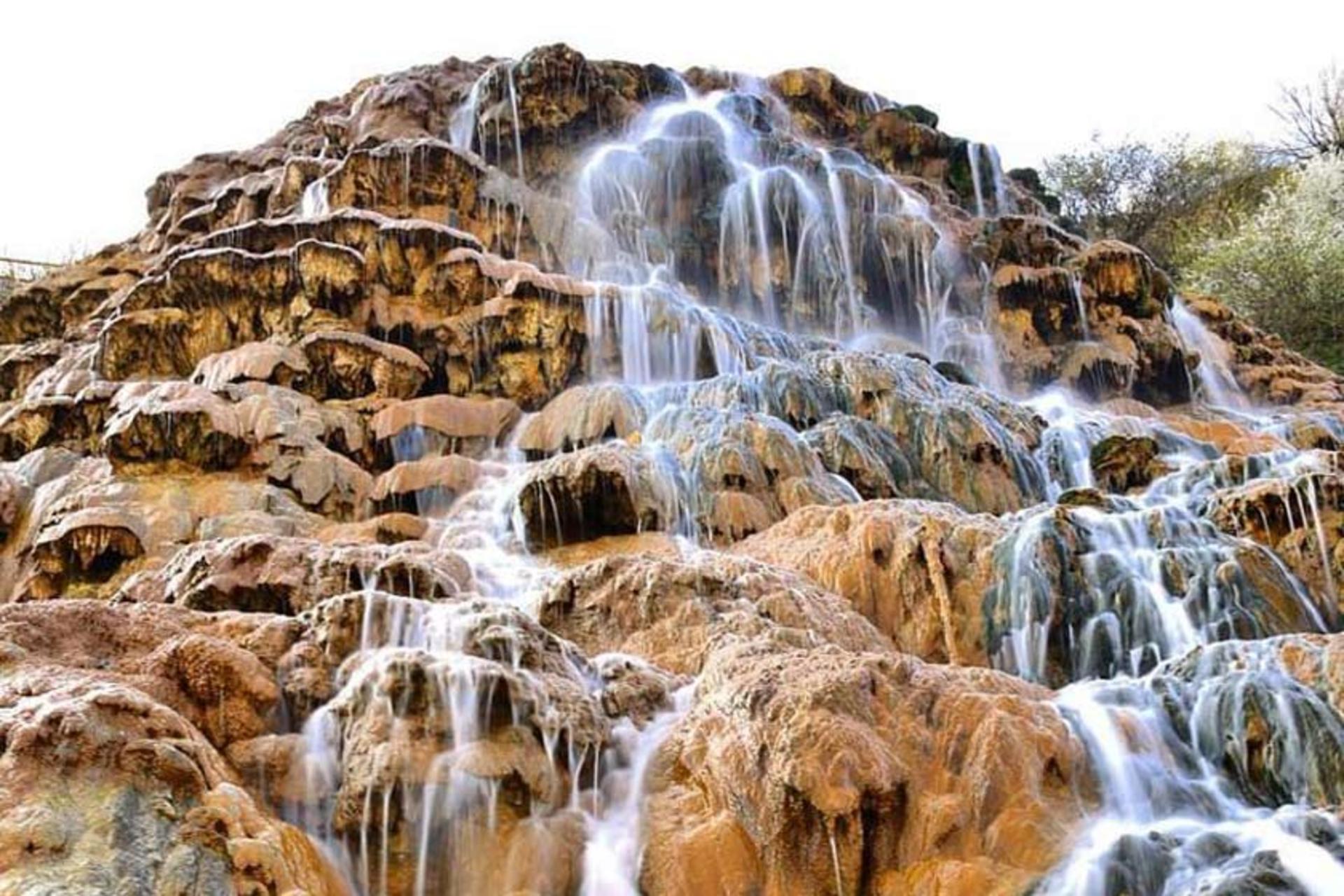 آبشار شورآب روی سنگ های سرخ کوهستانی از نمای نزدیک