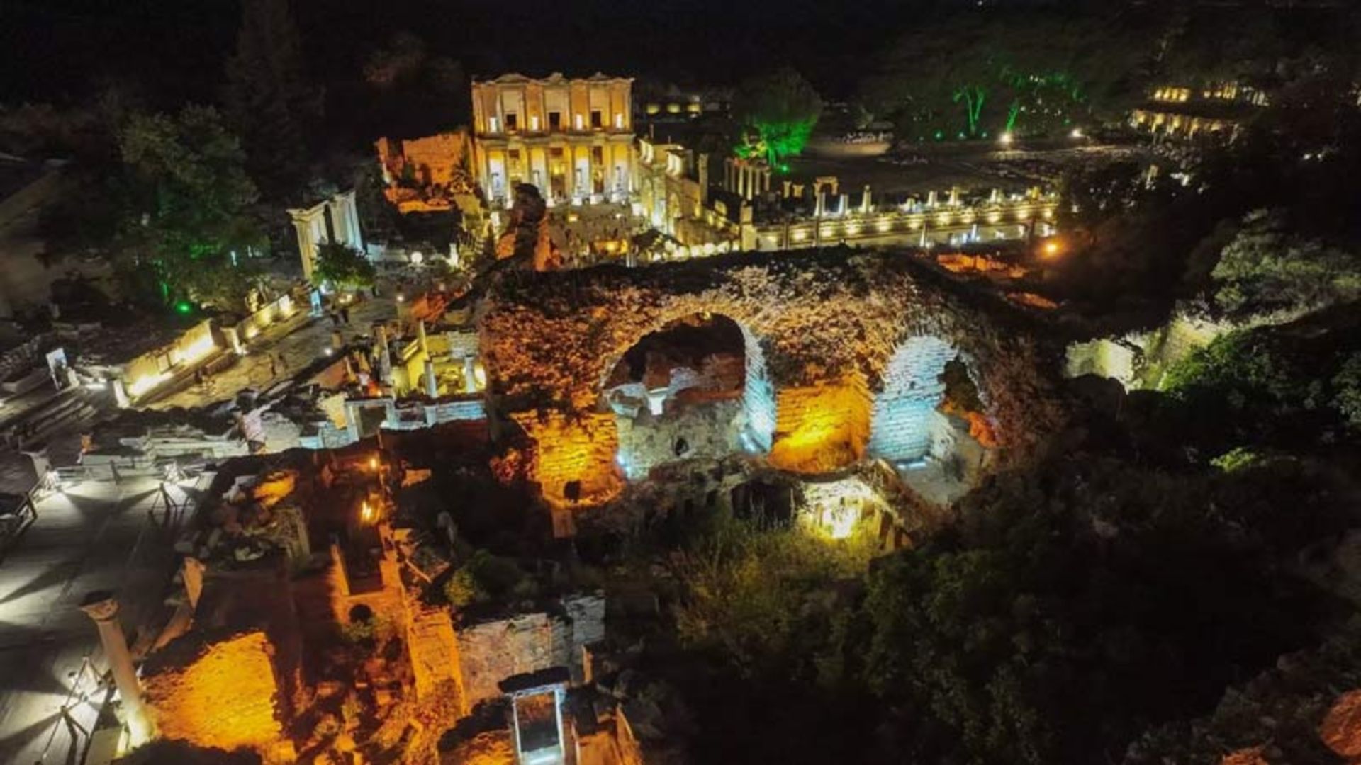 نمای عریض و هوایی از شهر افسوس در شب با نورپردازی رنگی بر روی ویرانه‌ها و کتابخانه سلسوس