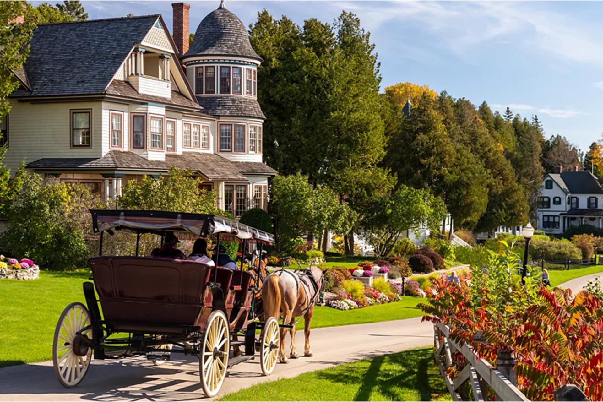 کالسکه اسبی در حال عبور از کنار خانه‌های سنتی جزیره مکیناک