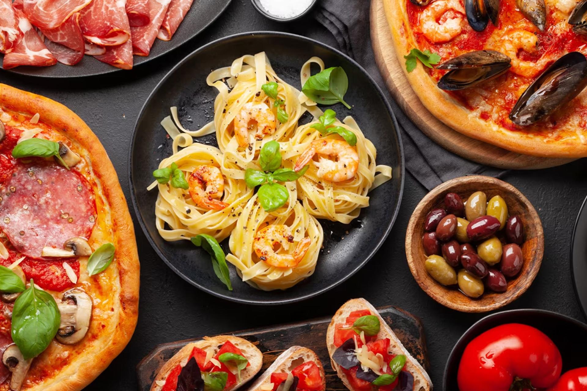 تصویری از سفره ایتالیایی شامل پاستا و غذاهای دیگر