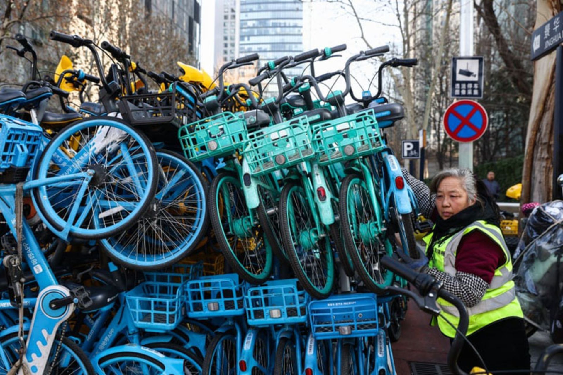 جمع‌آوری و روی هم چیدن دوچرخه‌های اشتراکی در مرکز پکن
