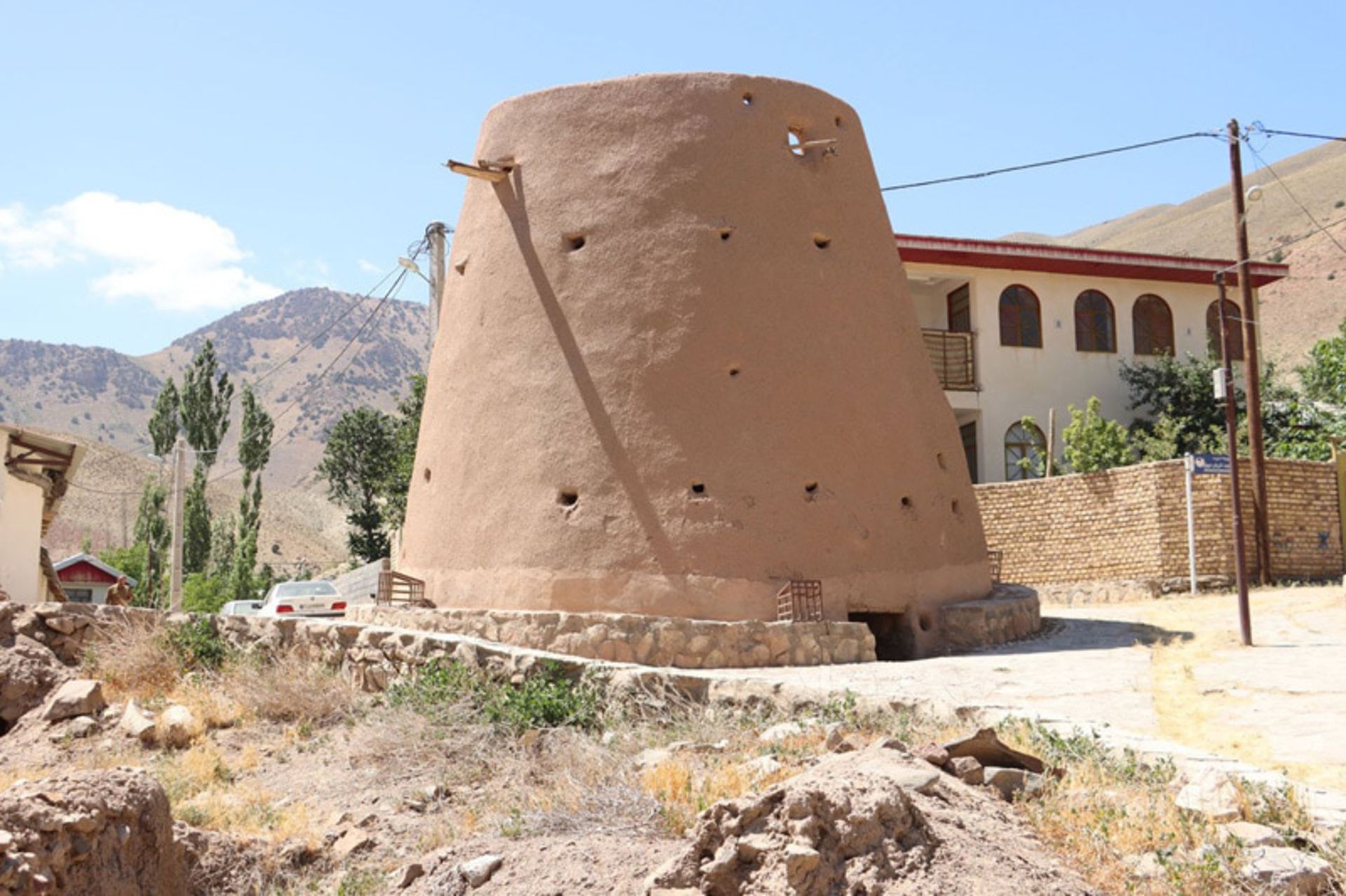 برج تاریخی گلی چاشم در چشم‌اندازی روستایی