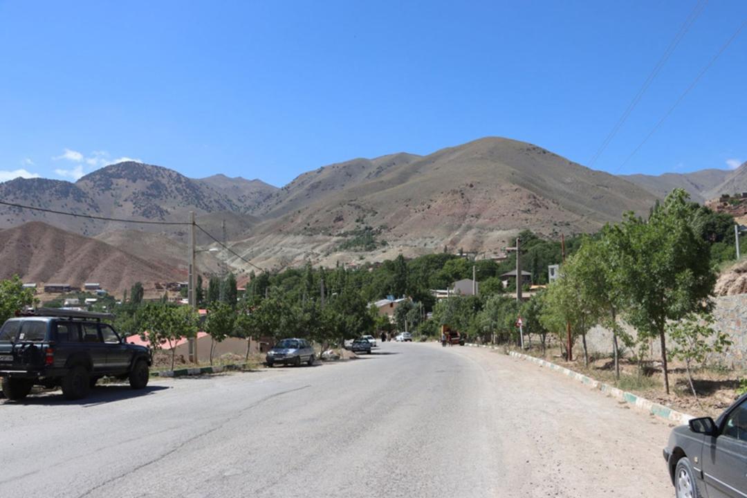 جاده‌ای آسفالت در میان کوهستان‌های سرسبز چاشم