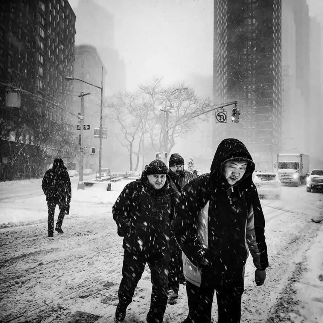 چند مرد در حال گذر کردن از خیابان برفی