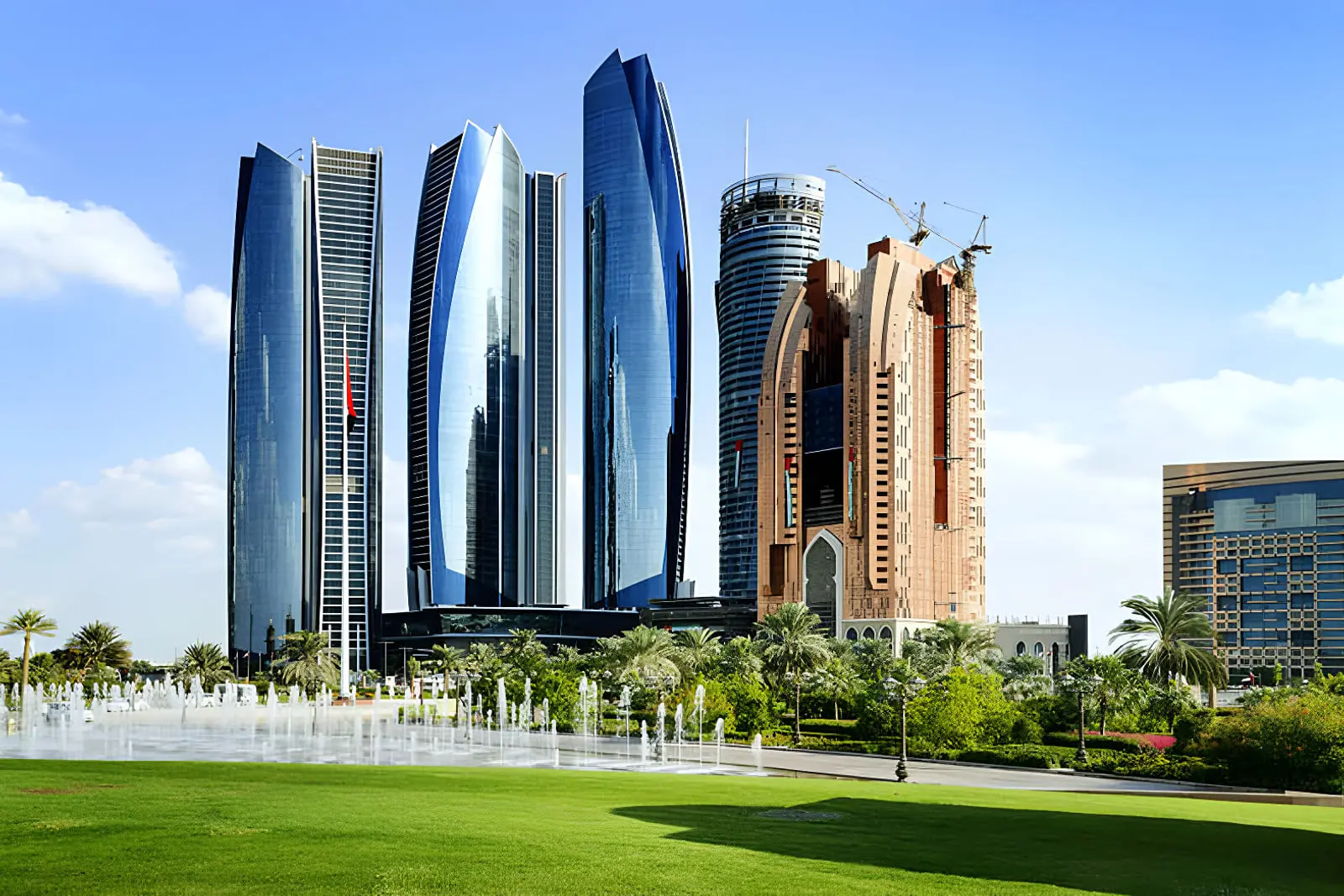 آسمان‌خراش‌های شیشه‌ای و بلند در شهر ابوظبی (Abu Dhabi) در کنار فضای سبز