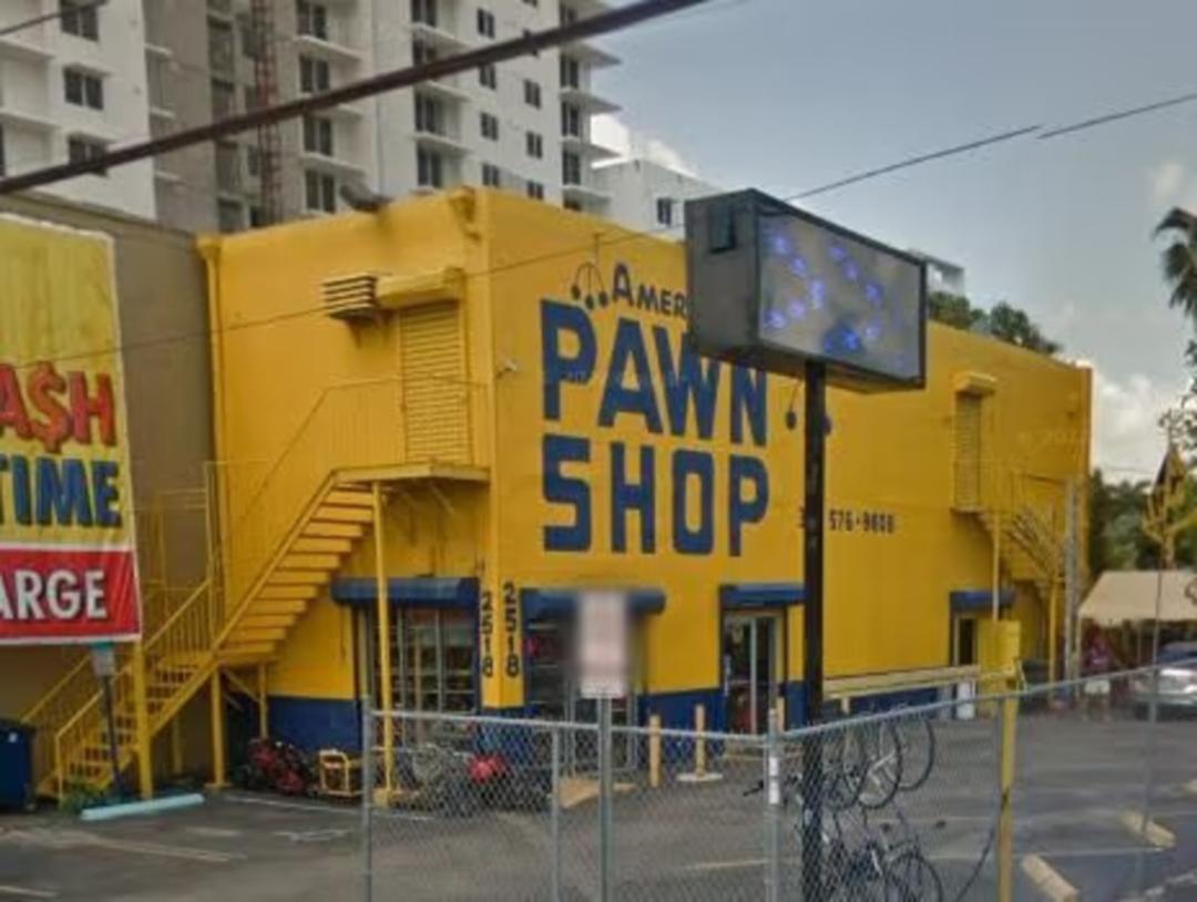 ساختمان زرد رنگ فروشگاه گروی آمریکایی (American Pawn Shop) با پله‌های بیرونی