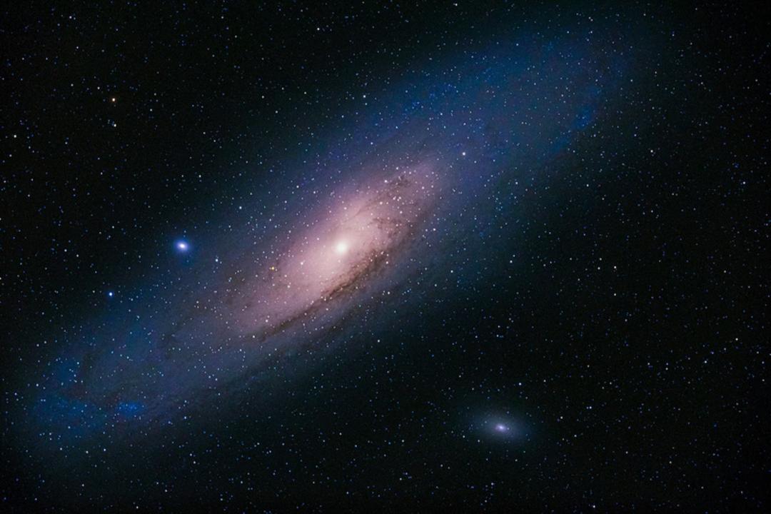 کهکشان آندرومدا (Andromeda Galaxy) با هسته درخشان در میان ستارگان