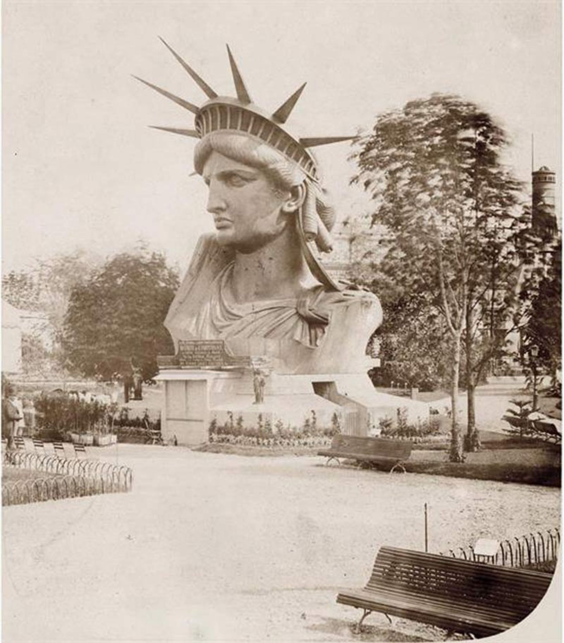 نمای نزدیک از سر و تاج مجسمه آزادی در حال نمایش در یک پارک عمومی قدیمی