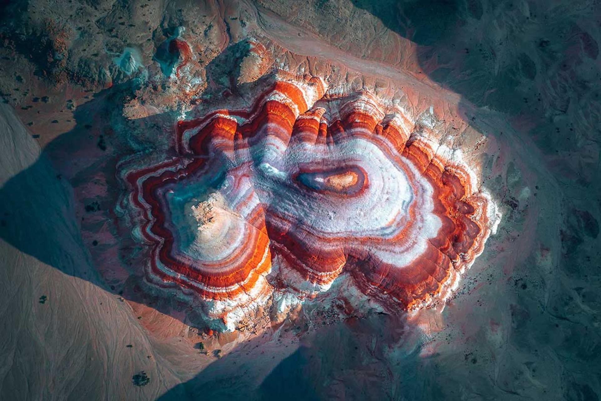 یک تپه لایه‌لایه با حلقه‌های رنگی قرمز، سفید و نارنجی