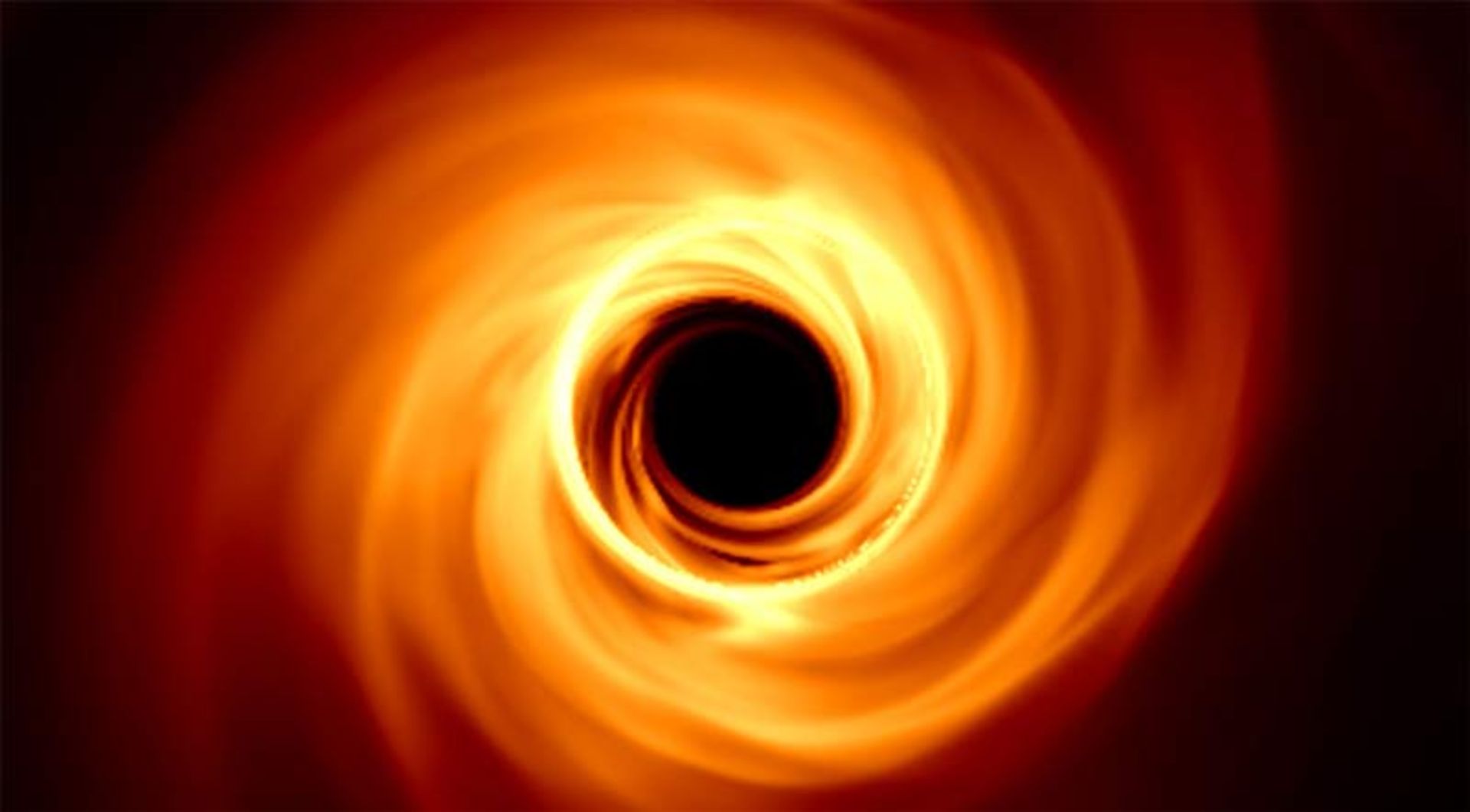 شبیه‌سازی رایانه‌ای از یک سیاه‌چاله با افق رویداد تاریک و دیسک برافزایشی درخشان به رنگ نارنجی و زرد.