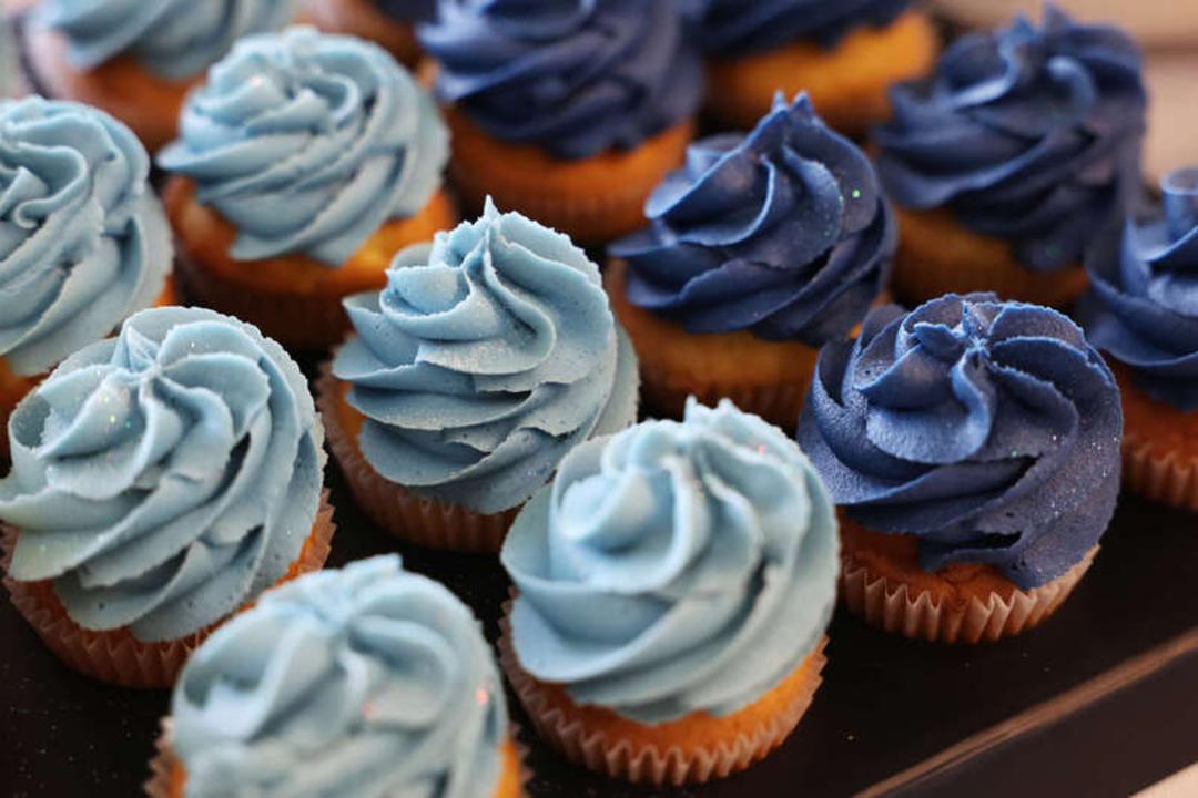 کاپ‌کیک‌های شیرین با کرم‌های رنگی آبی روشن و سرمه‌ای