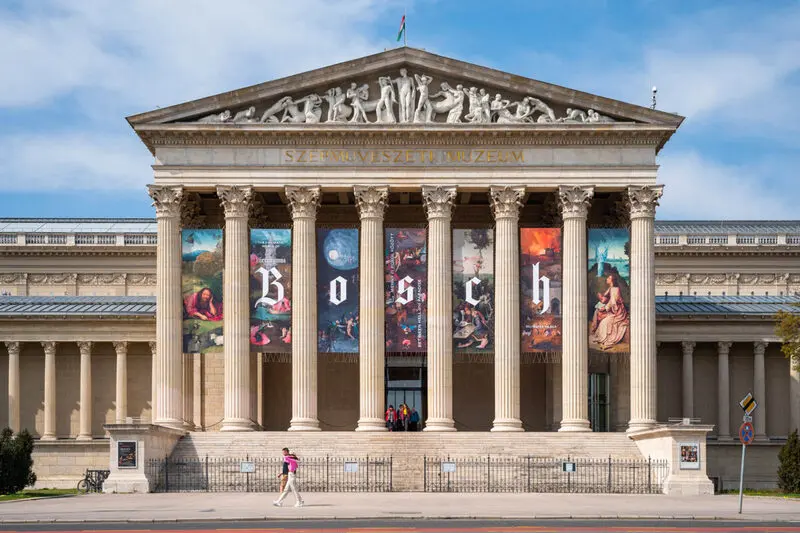 موزه هنر بوداپست (Museum of Fine Arts) با ستون‌های کلاسیک و بنرهای نمایشگاه بوش