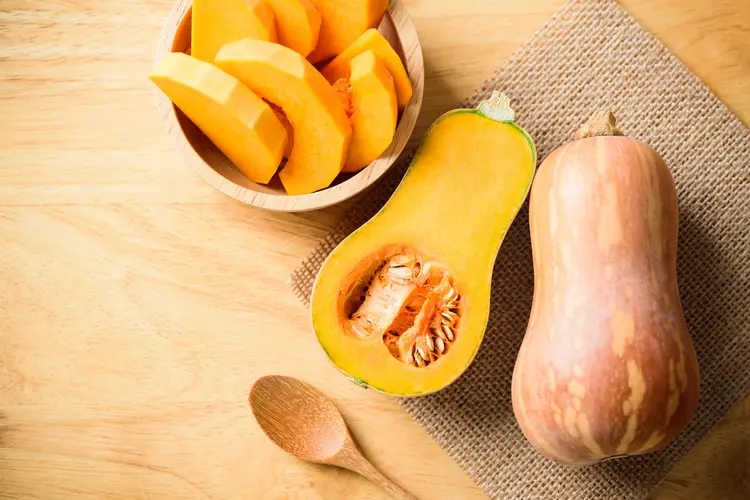 کدو حلوایی (Butternut Squash) کامل و تکه‌های برش خورده در ظرف چوبی