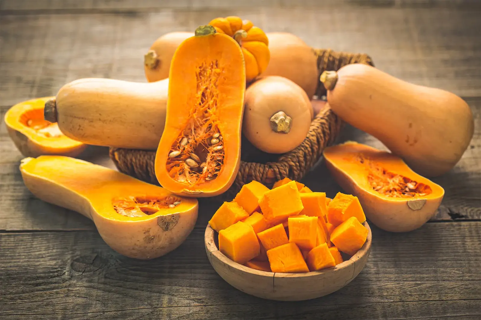 کدو حلوایی (Butternut Squash) کامل و تکه‌های خرد شده در ظرف چوبی