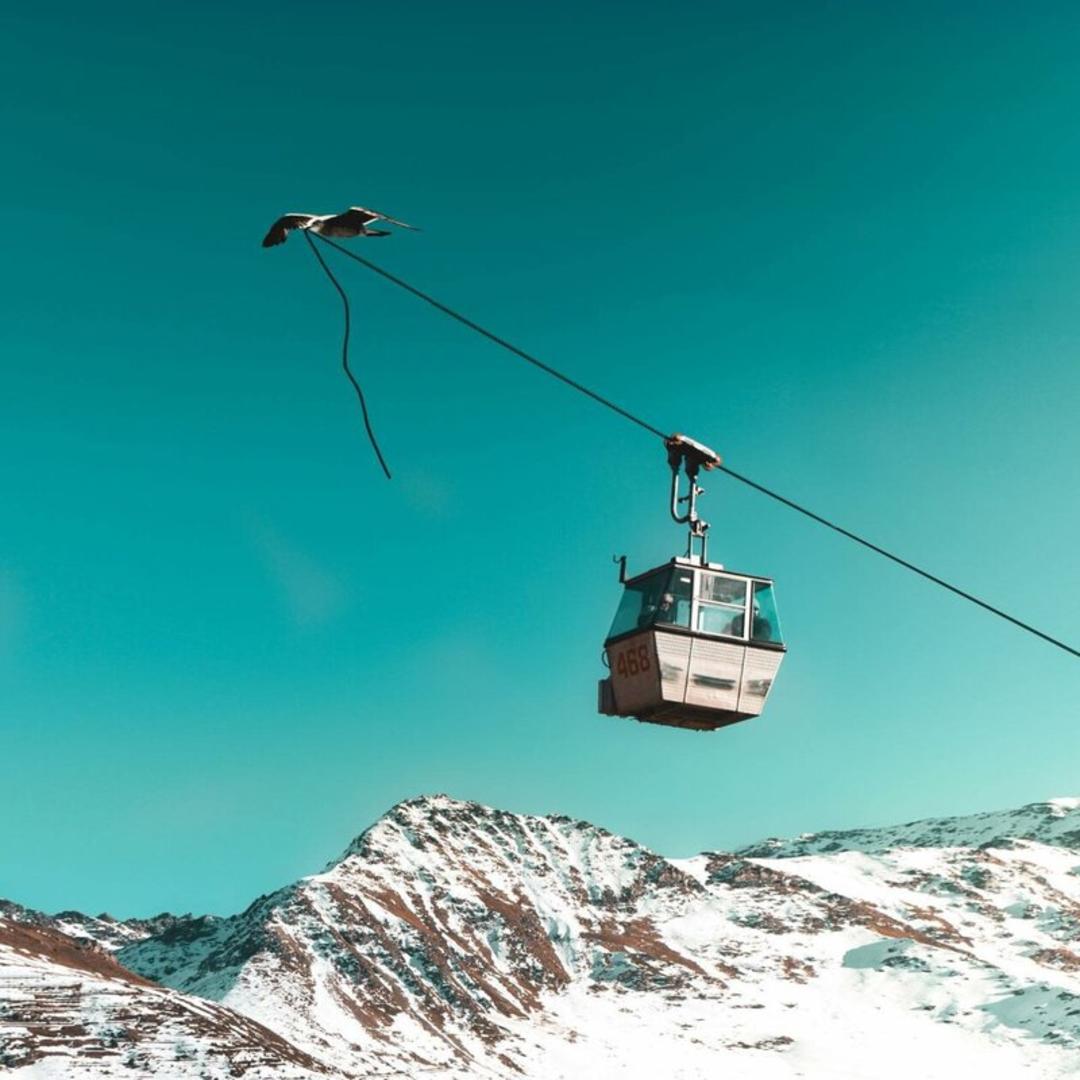 تله‌کابین (Cable Car) در حال حرکت بر فراز کوه‌های پوشیده از برف