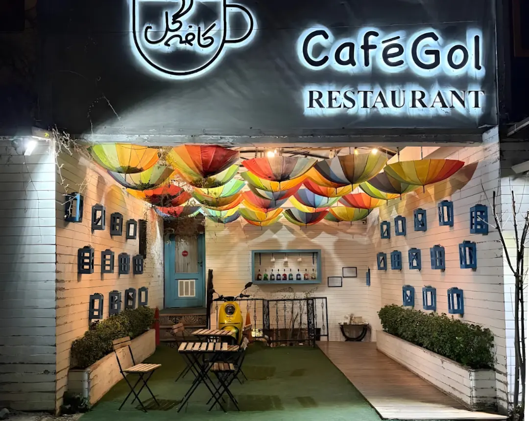 ورودی کافه گل با چترهای رنگی تزئین شده در شب