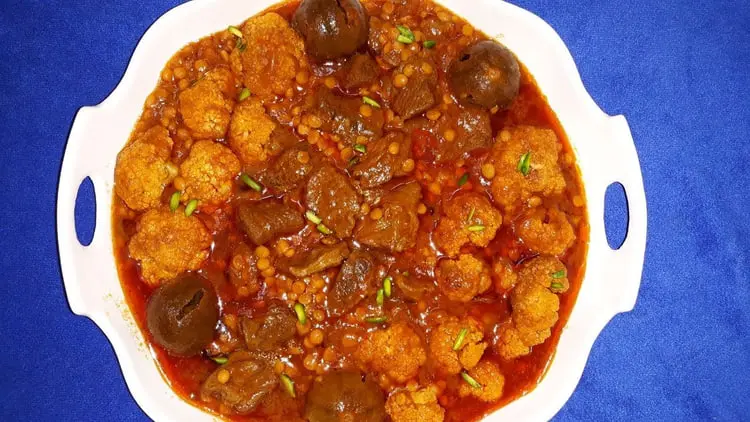 خورش گل کلم و عدس با تکه‌های گوشت در ظرف سفید