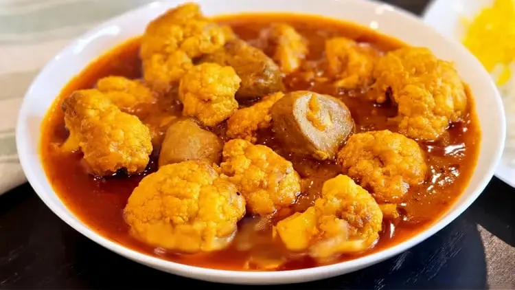خورش گل کلم در ظرف سفید با سس قرمز رنگ