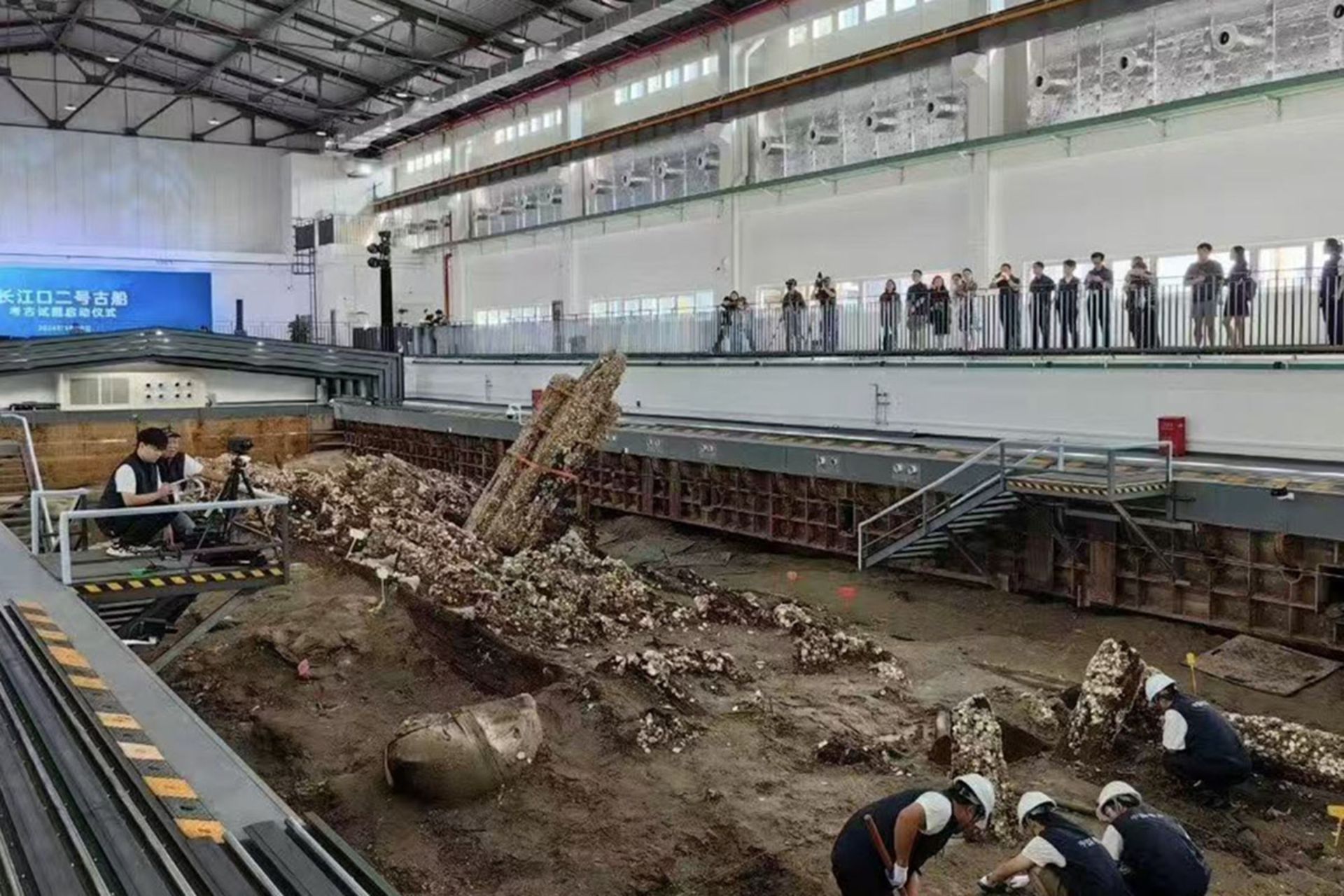 باستان‌شناسان در حال کار بر روی بدنه چوبی و گل‌آلود کشتی