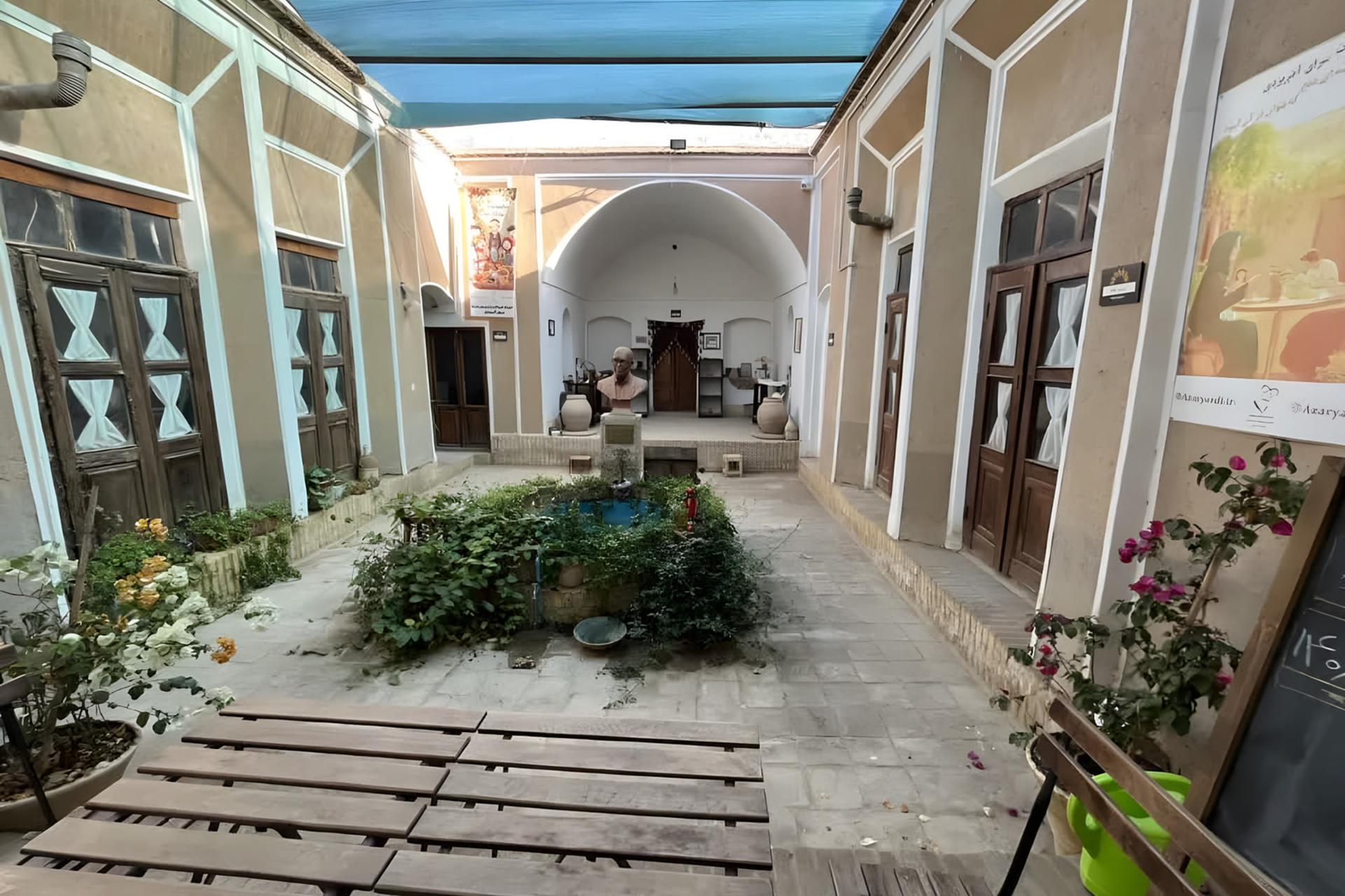 حیاط مرکزی خانه گلی (Azaryadi House) با حوضچه و گیاهان در مرکز