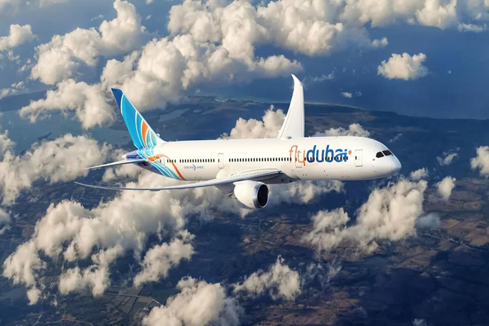 هواپیمای فلای‌دبی (flydubai) در حال پرواز میان ابرها بر فراز زمین