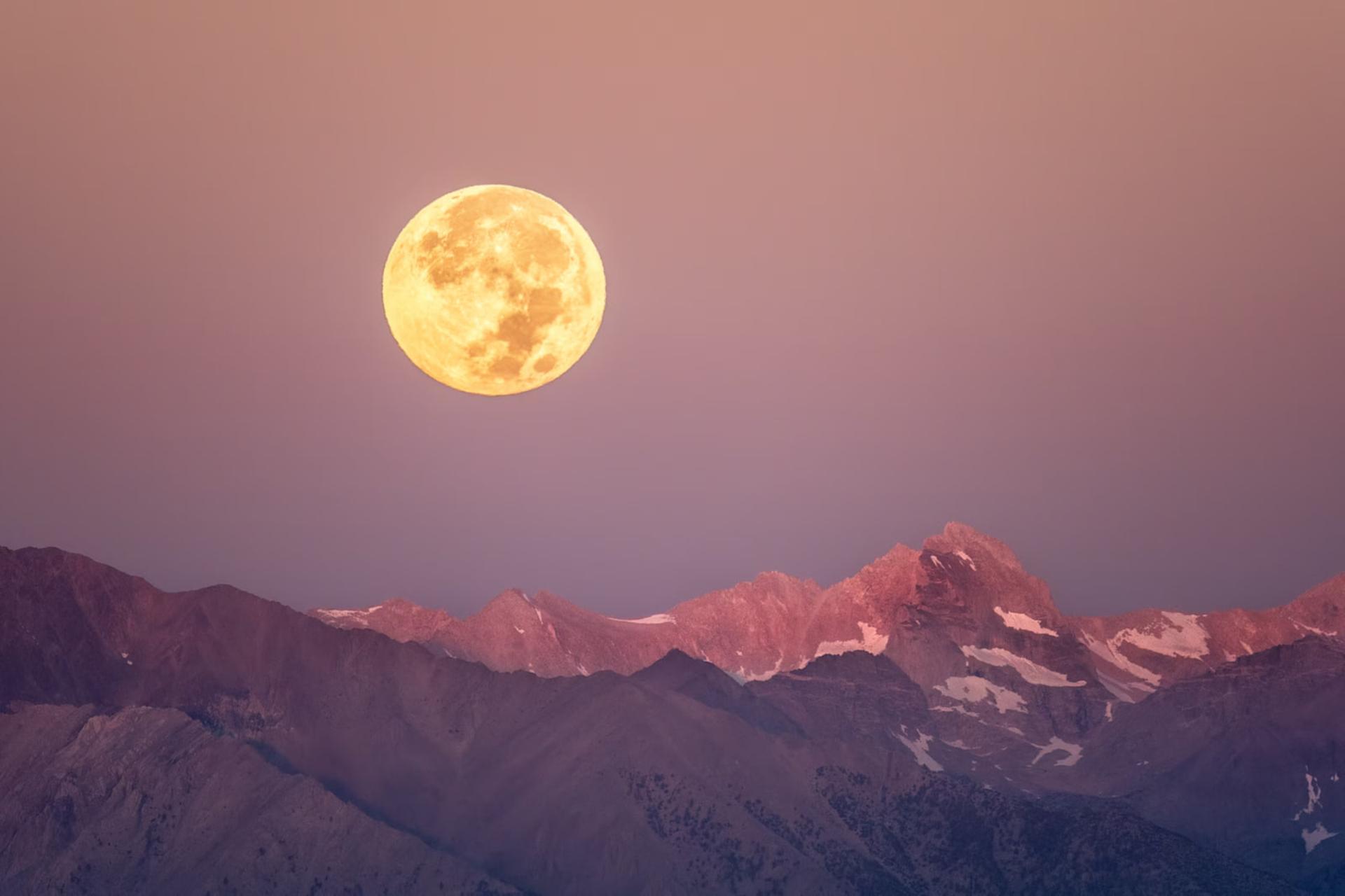ماه کامل (Full Moon) در آسمان بالای رشته‌کوه با قله‌های پوشیده از برف