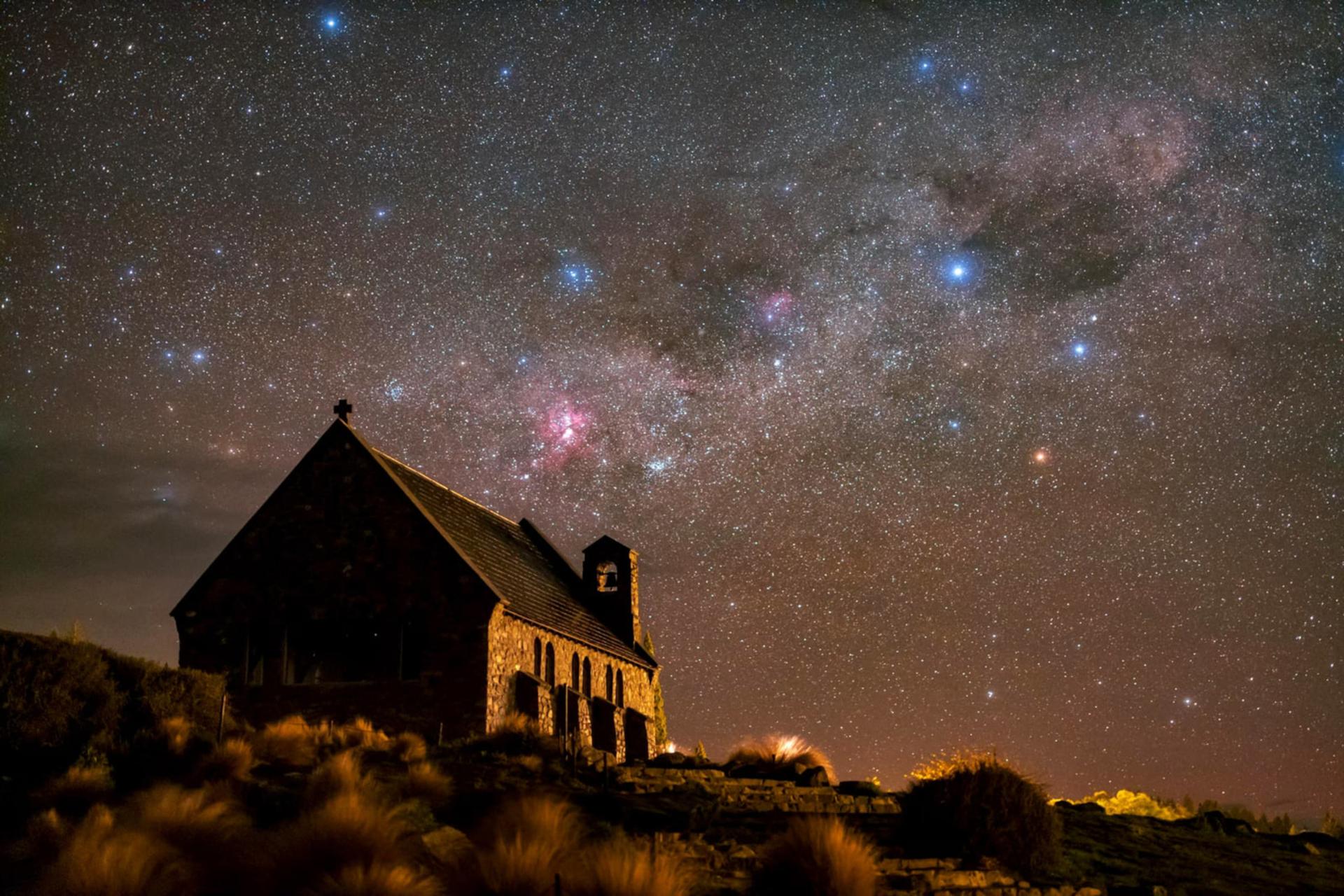 منظره کهکشان راه شیری (Milky Way) بالای یک کلیسای قدیمی در شب
