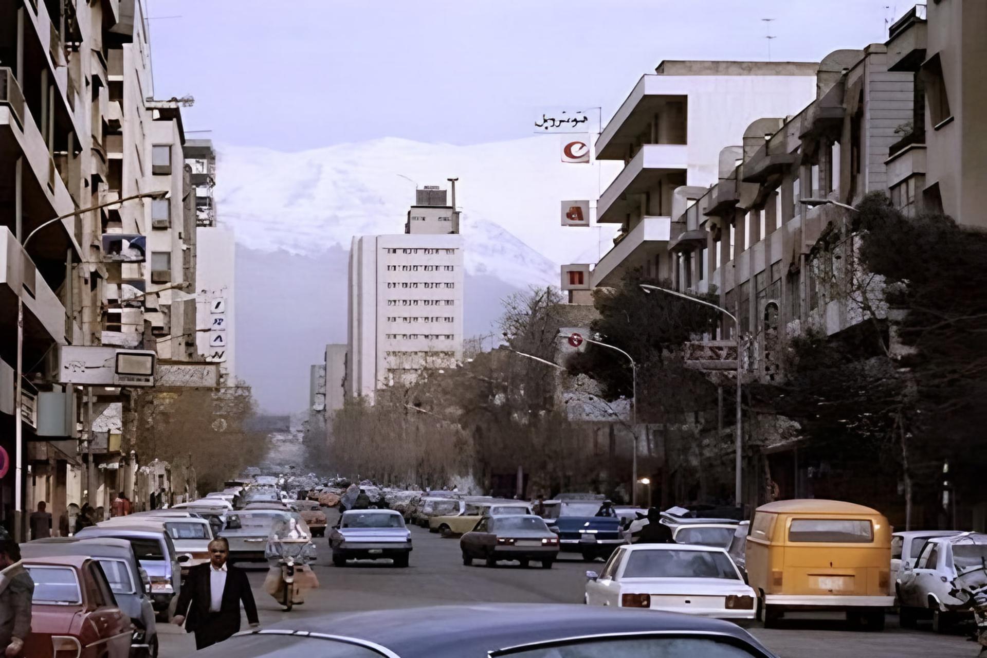 نمای خیابان ویلا در تهران با کوه‌های پوشیده از برف البرز در پس‌زمینه