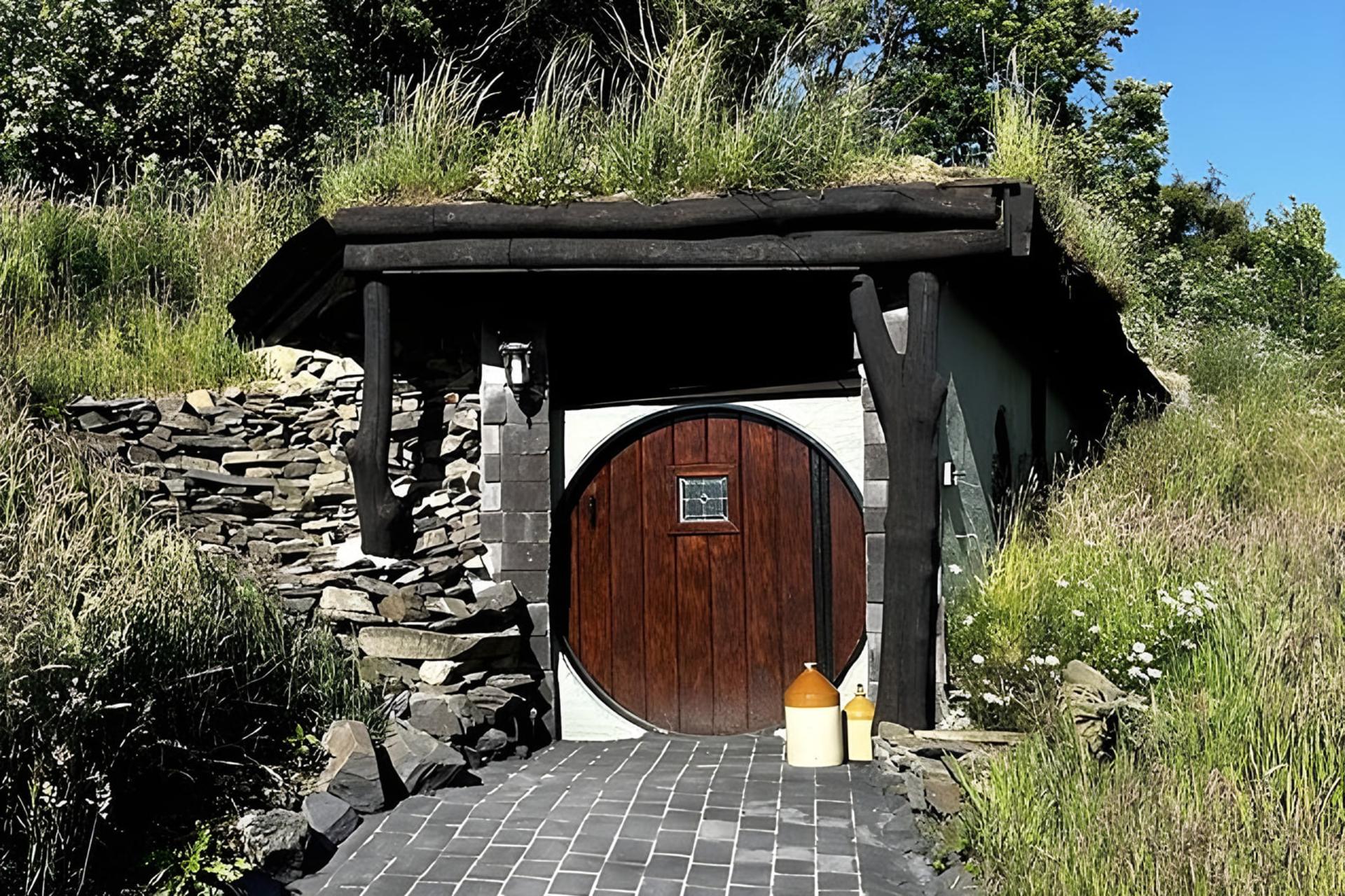 خانه هابیتی (Hobbit Hole) با درِ چوبی گرد در دل تپه