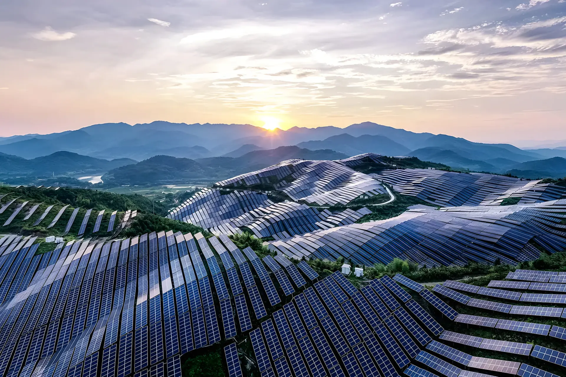 پنل‌های خورشیدی (Solar Panels) نصب شده روی دامنه‌های کوهستانی در هنگام غروب