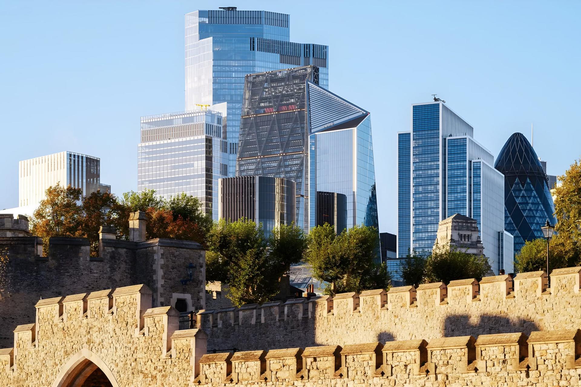 ساختمان‌های مدرن و آسمان‌خراش‌های لندن در پس‌زمینه دیوارهای تاریخی برج لندن (Tower of London)
