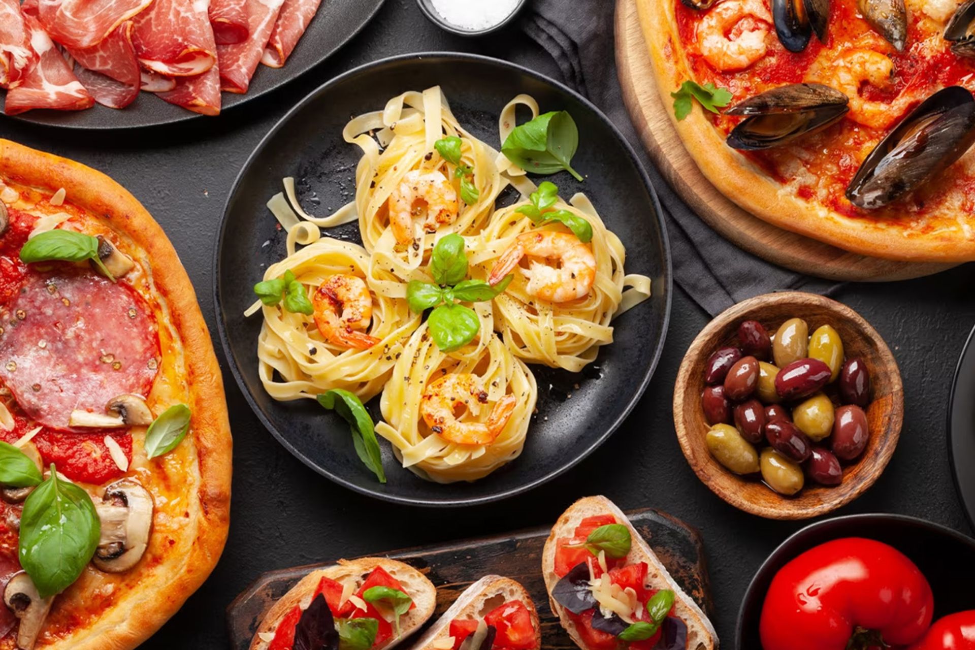 تصویری از سفره ایتالیایی شامل پاستا و غذاهای دیگر