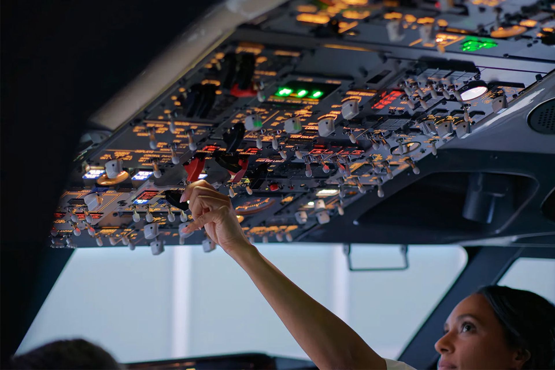 یک خلبان زن در حال تنظیم  یک کلید یا اهرم 