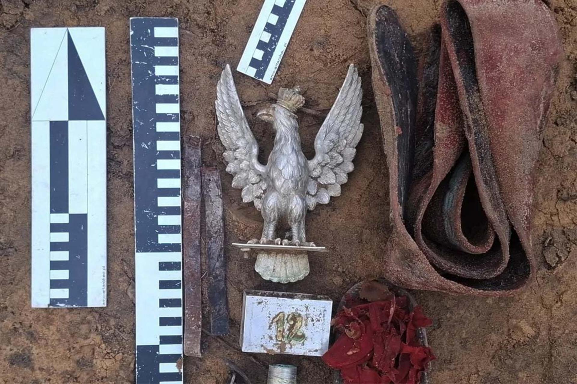 یک نشان عقاب به همراه چند وسیله دیگر در میان خاک