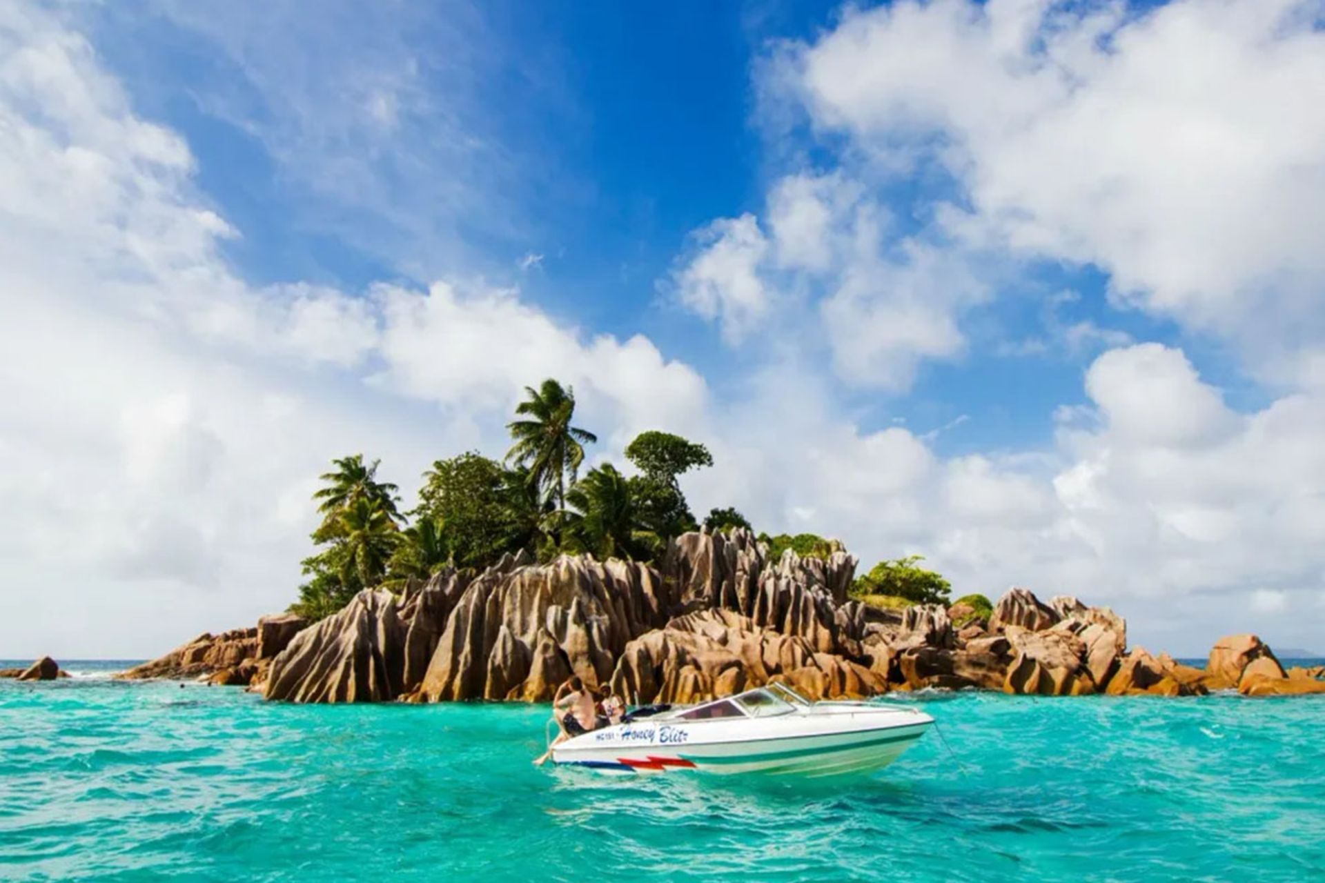 یک قایق تندروی سفید در آب‌های زلال و فیروزه‌ای سیشل