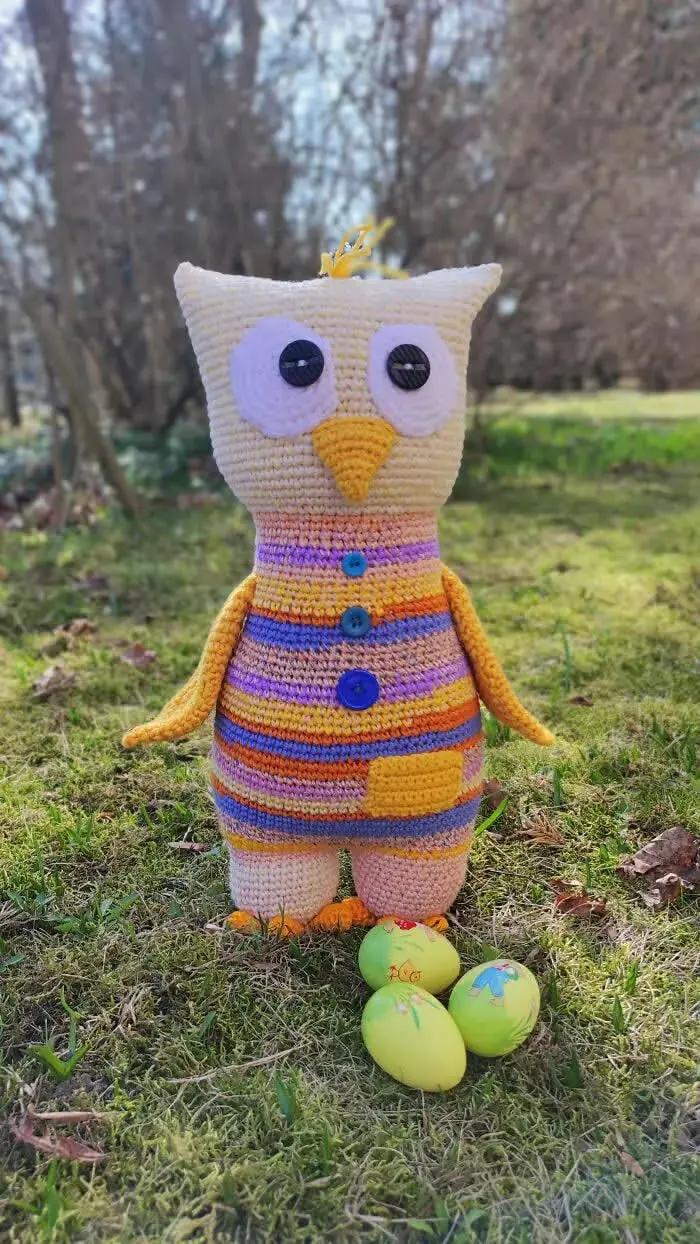 عروسک قلاب‌بافی (Amigurumi) با بدن مخطط و چشم‌های بزرگ در فضای باز