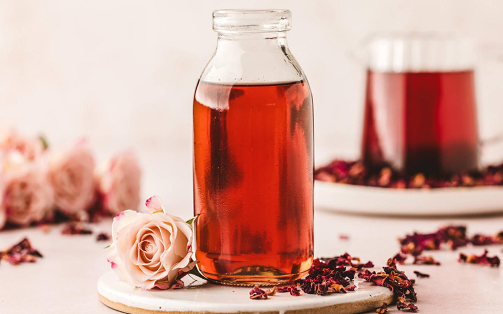 یک شیشه شربت گل محمدی با گل های محمدی