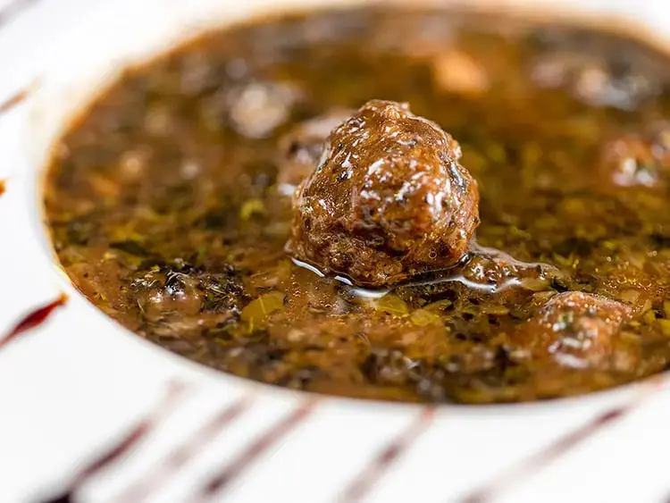 خورش داوود پاشا با گوشت قلقلی و سس رب انار در ظرف سفید