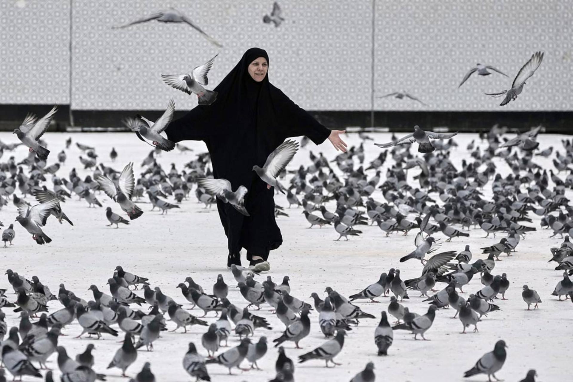 بازی زن مسلمان با کبوتران در مکه