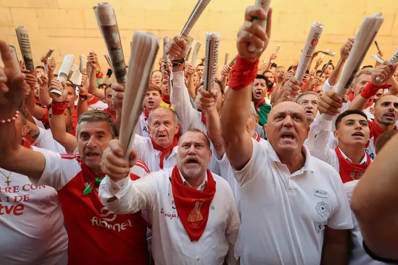 شرکت کنندگان آوازه خوان در  جشنواره گاوبازی شهر پامپلونا، اسپانیا