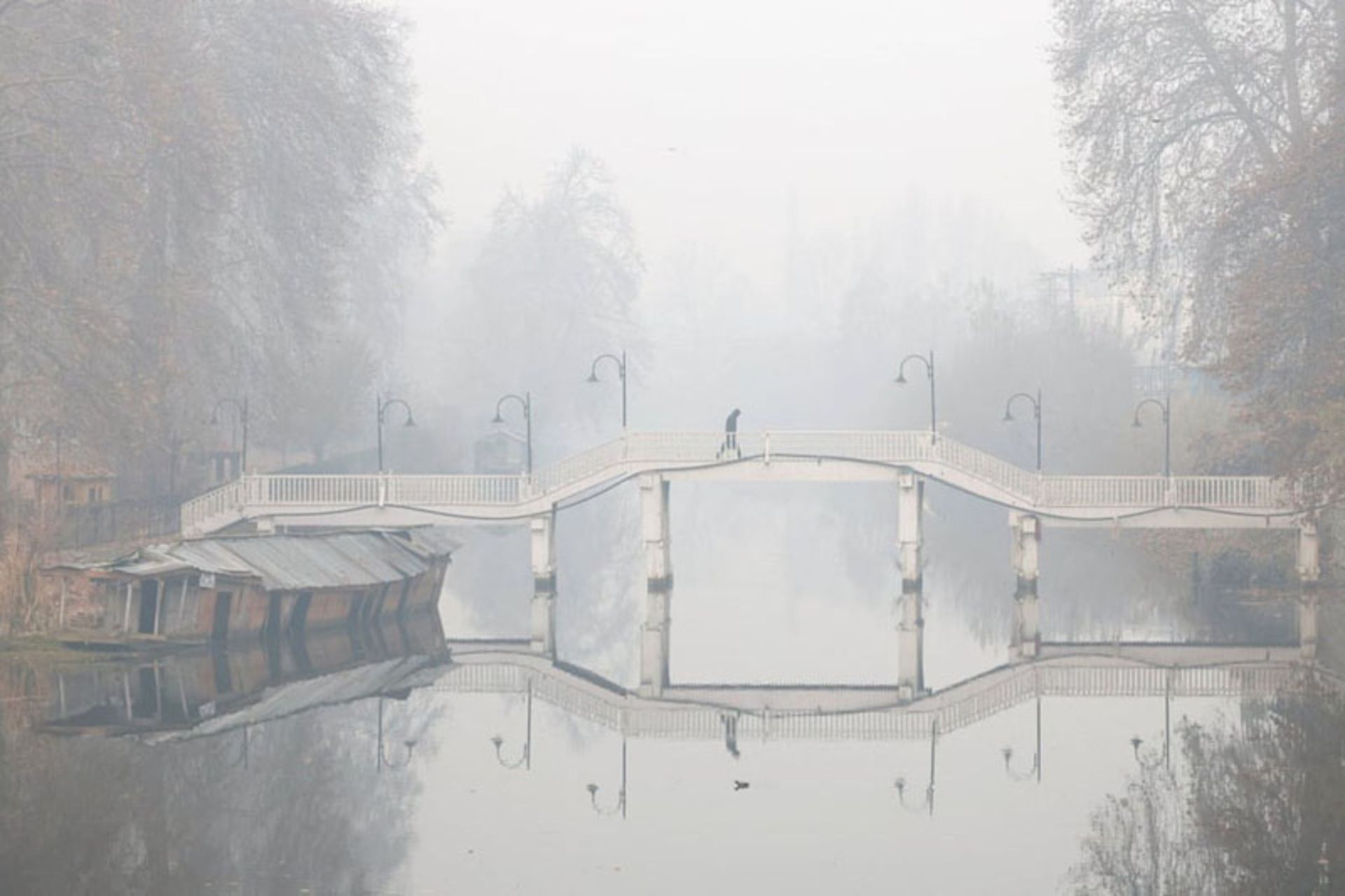 عبور مردی از پل چوبی در مه غلیظ صبحگاهی کشمیر، هند