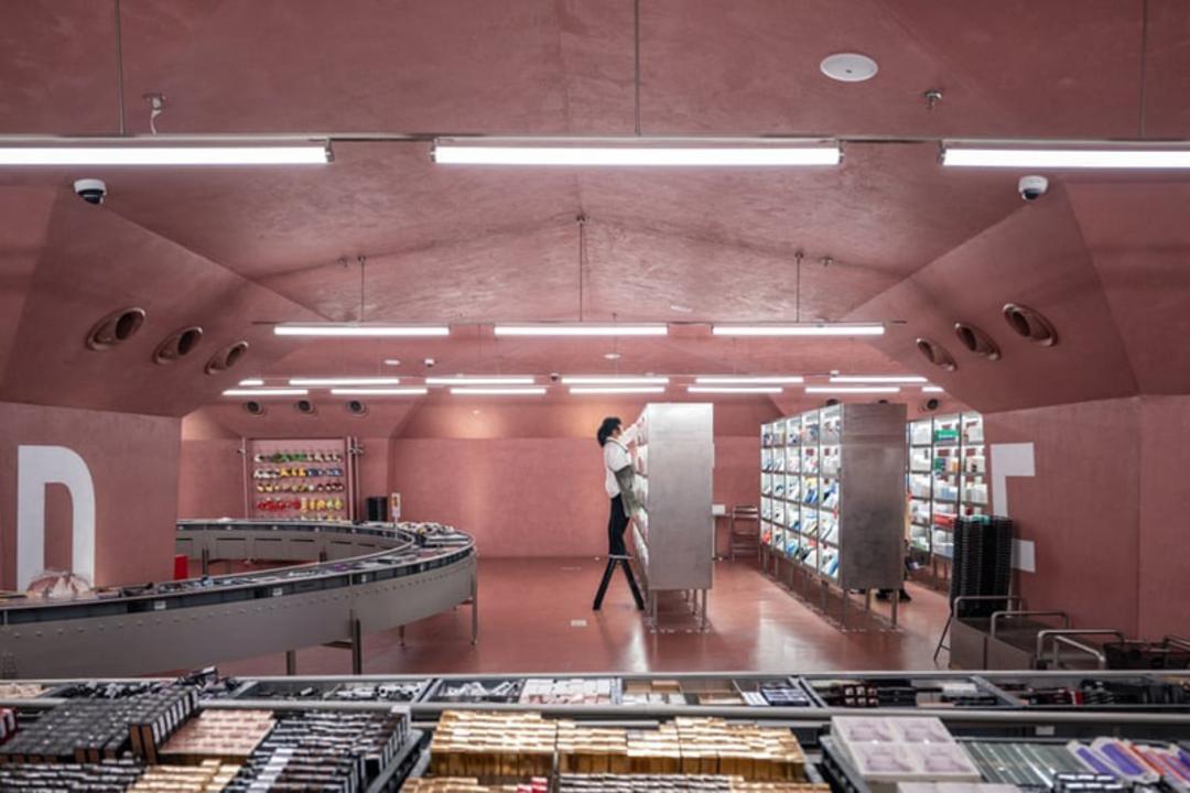 کارگری در حال چیدن قفسه‌ها در فروشگاه جدیدی در شهر چونگ‌چینگ